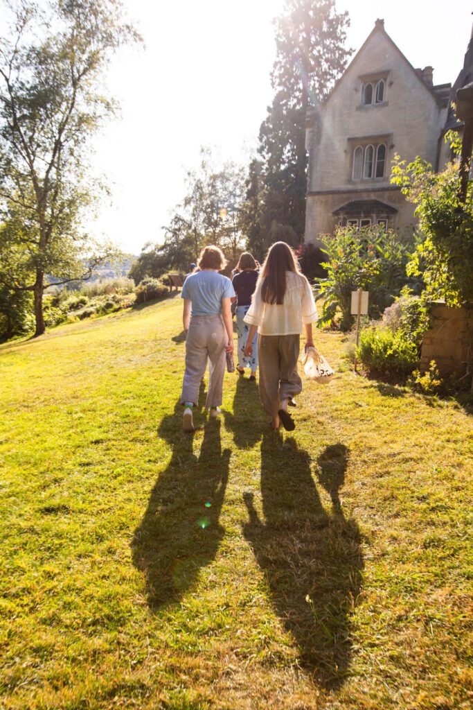 A group of fundraisers are walking towards a house in the sun set.