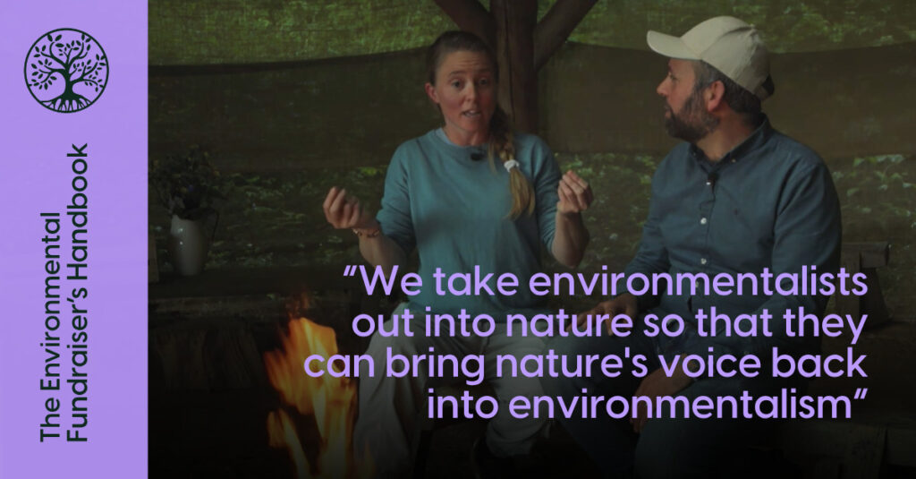 A white woman with blonde hair and a white man wearing a white cap are sitting around a fire outdoors. Text in purple over the top says: “We take environmentalists out into nature so that they can bring nature's voice back into environmentalism”